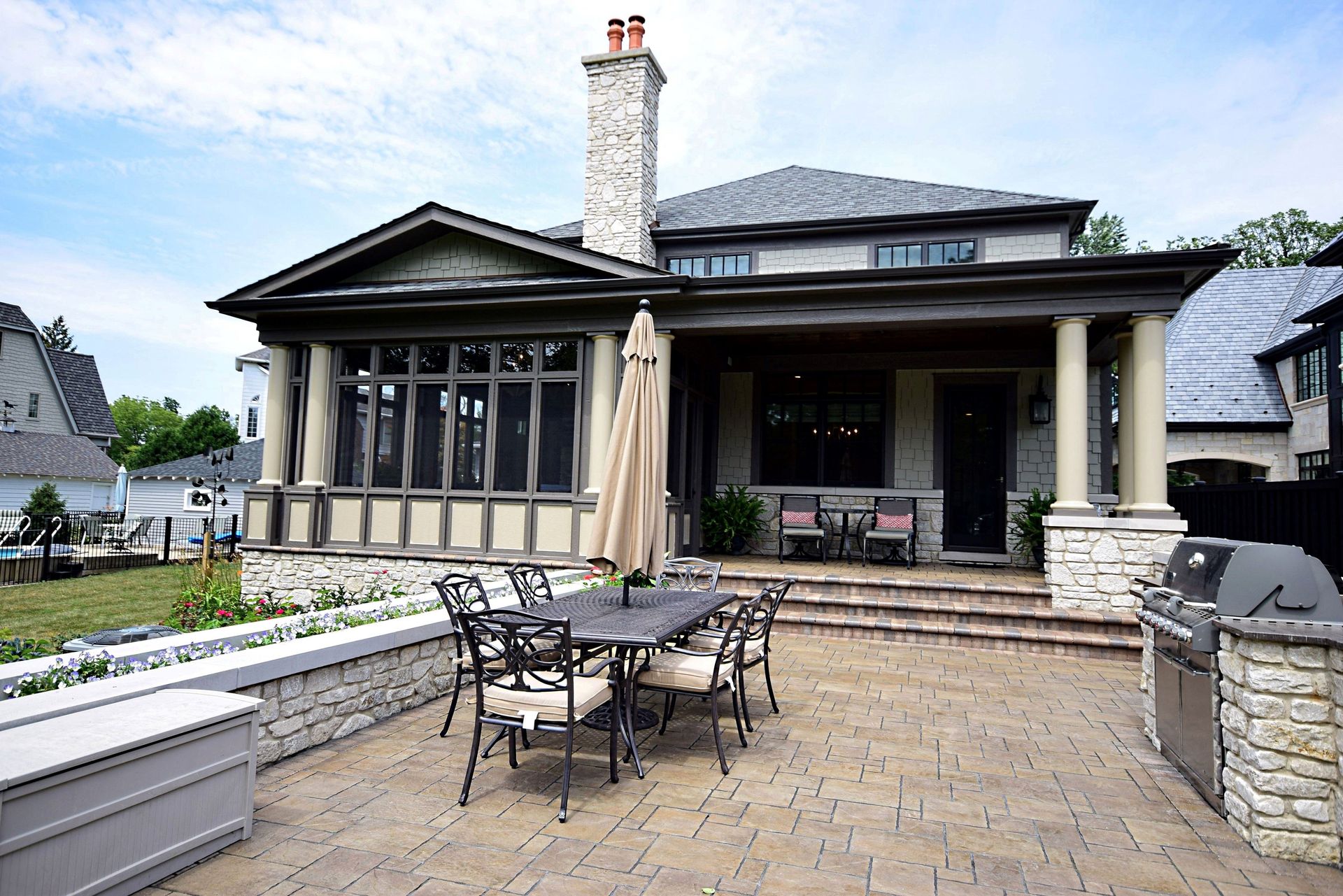 There is a table and chairs on the patio in front of the house.