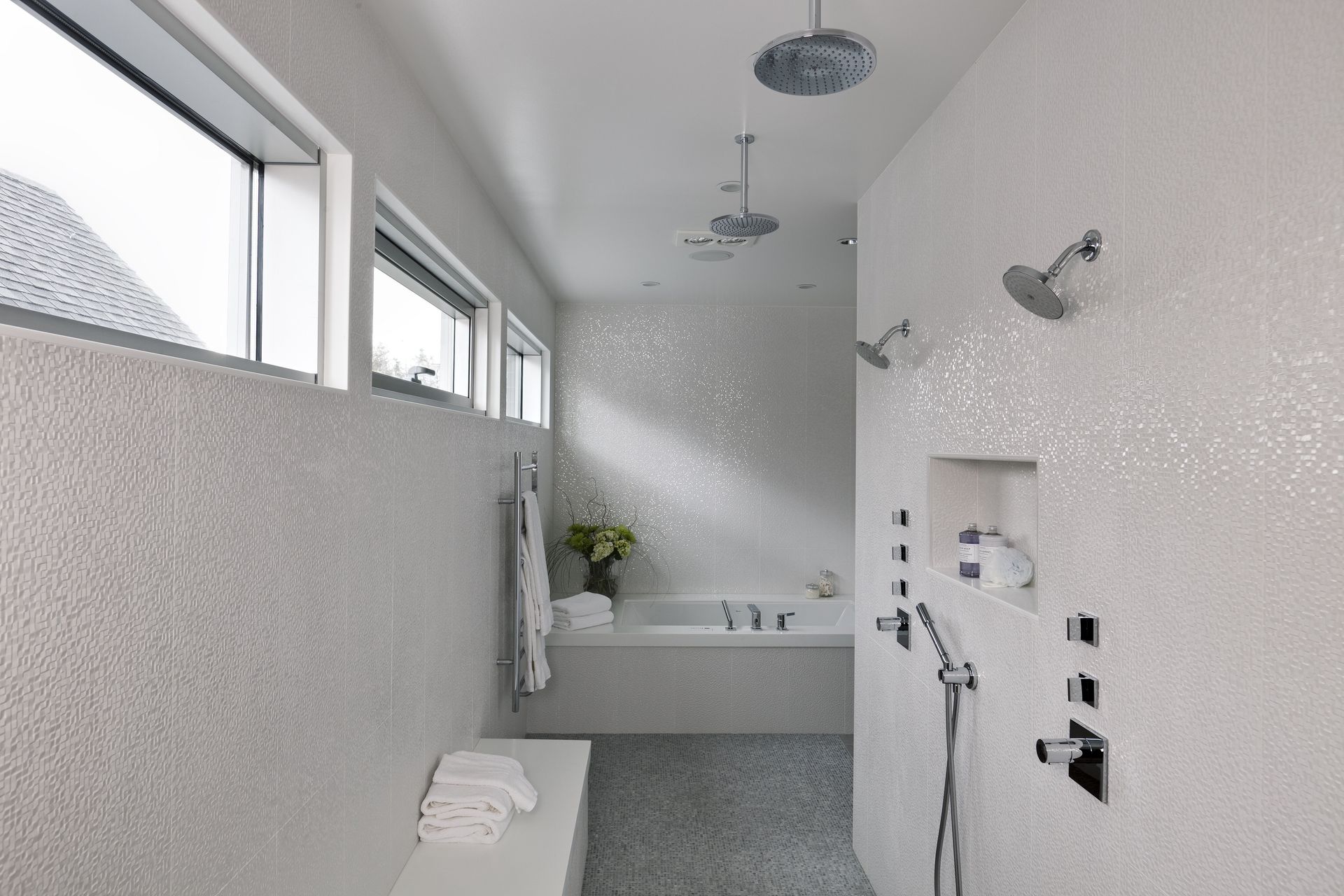 A bathroom with a tub , shower , and window.