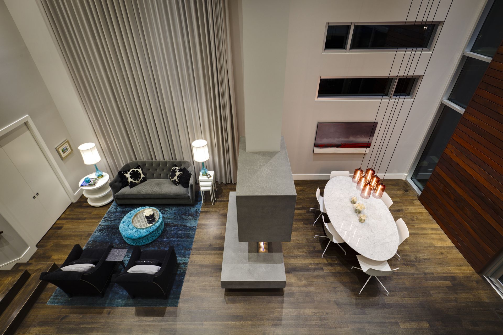 An aerial view of a living room and dining room with a fireplace.