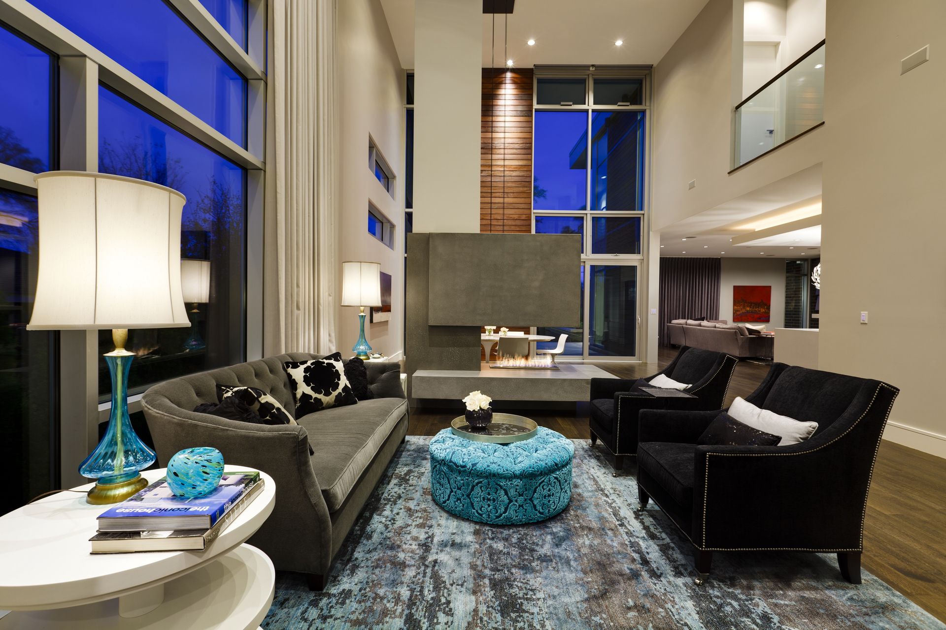 A living room with a couch and chairs and a blue rug