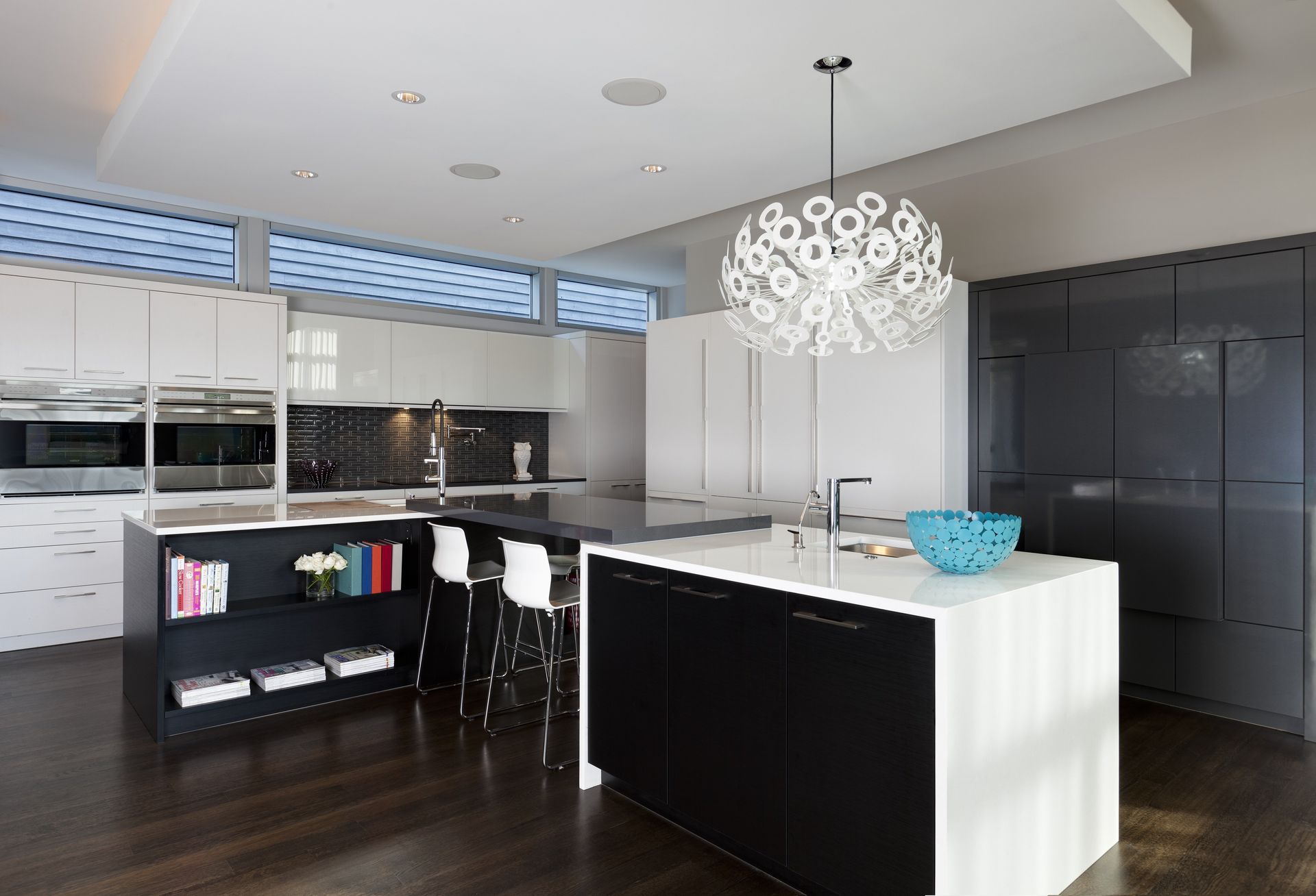 A kitchen with a large island and a chandelier hanging from the ceiling