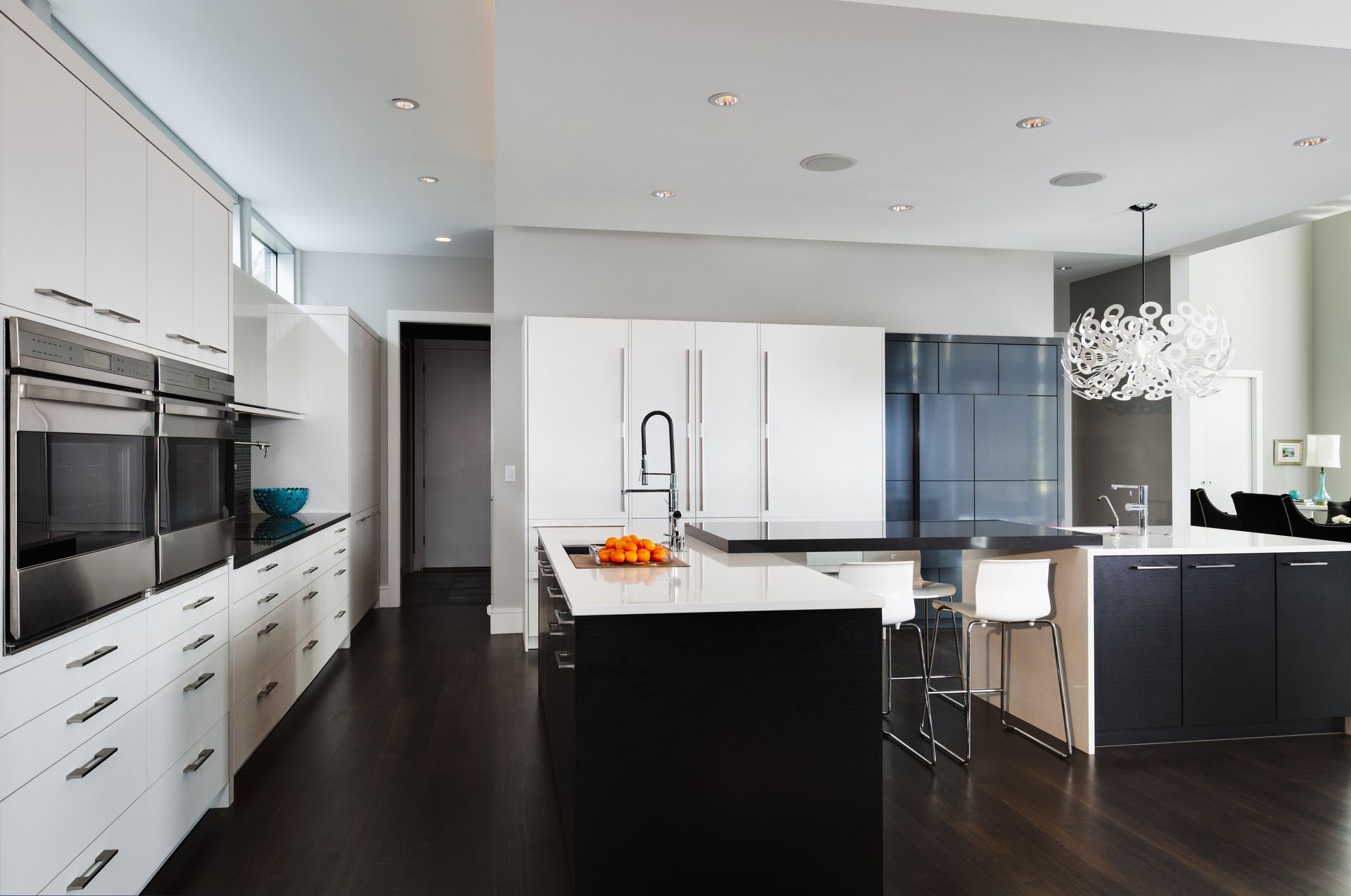 A kitchen with black and white cabinets and stainless steel appliances