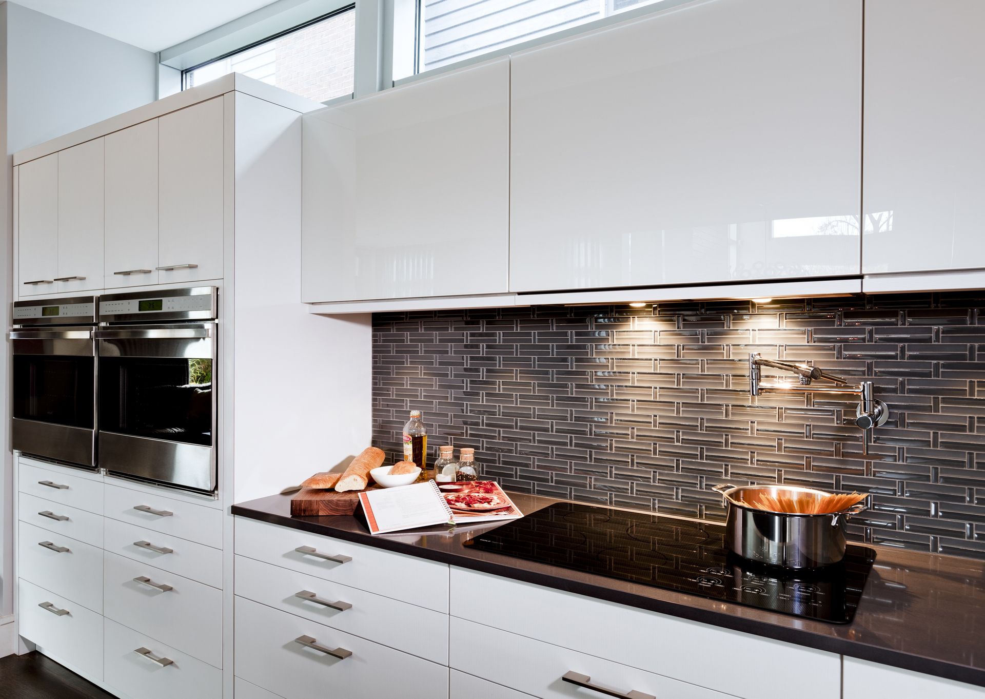 A kitchen with white cabinets and black counter tops