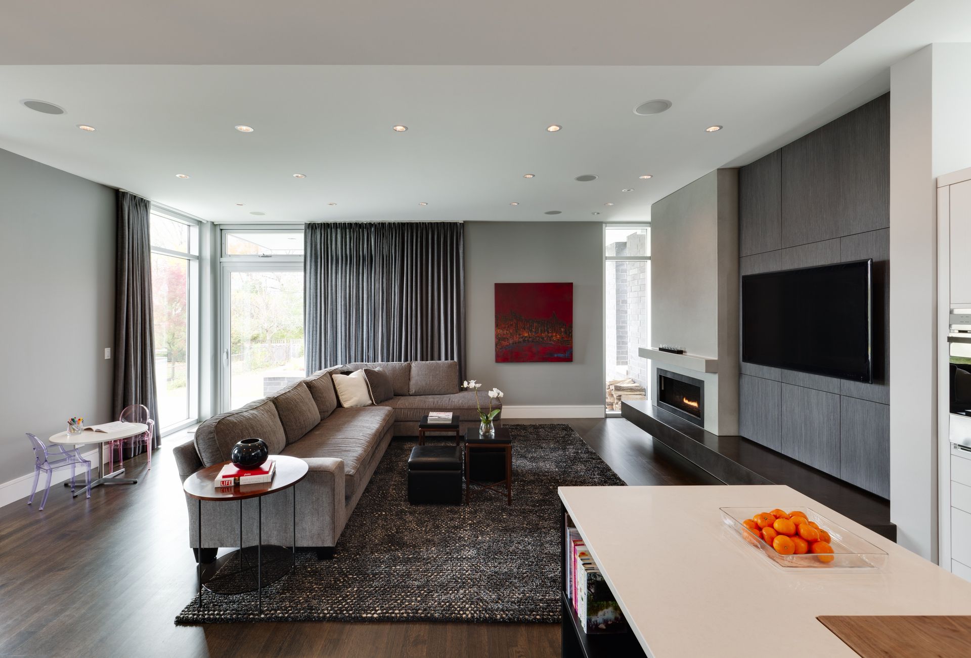 A living room with a large sectional couch and a flat screen tv