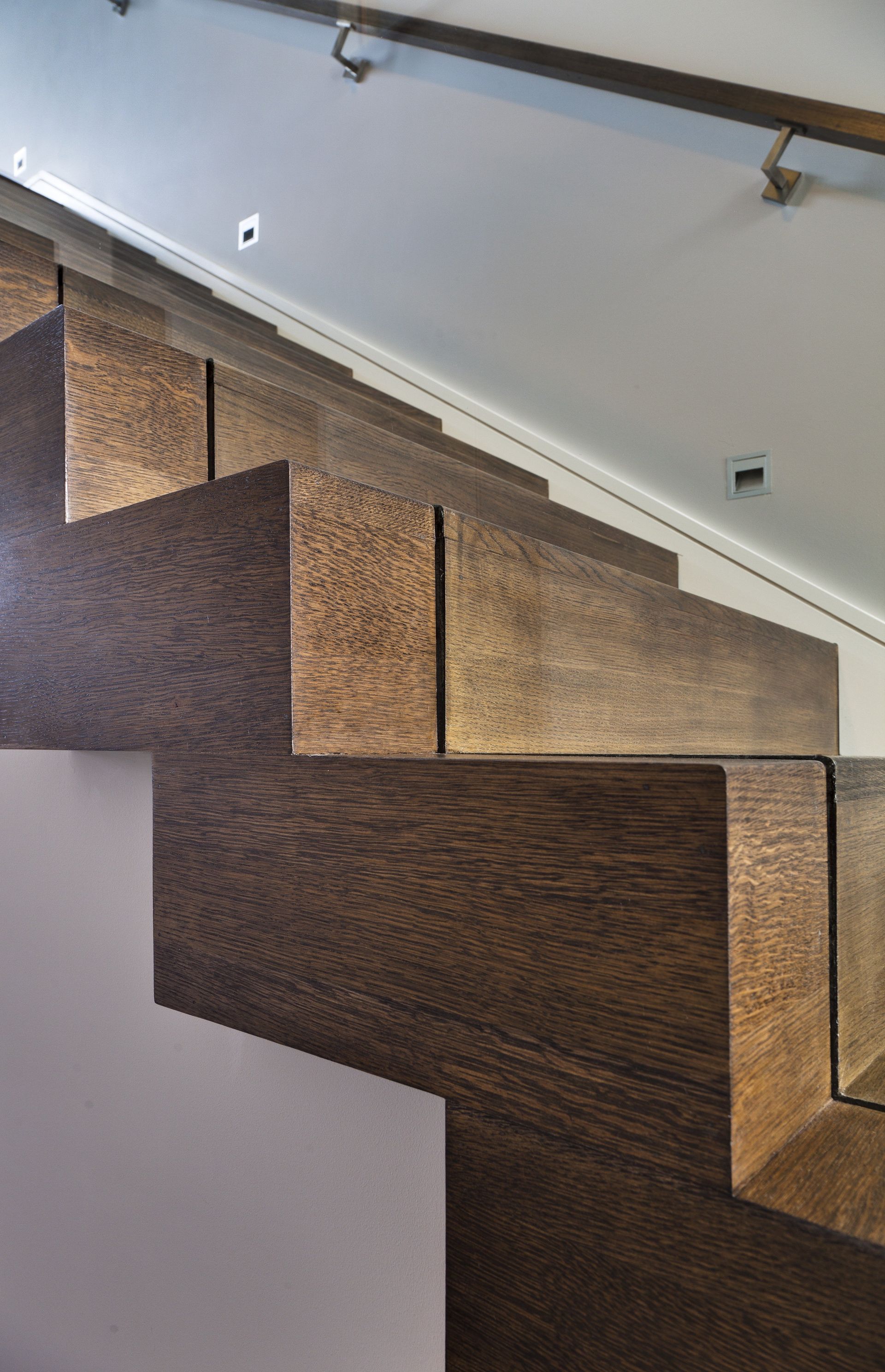 A close up of a wooden staircase with a metal railing