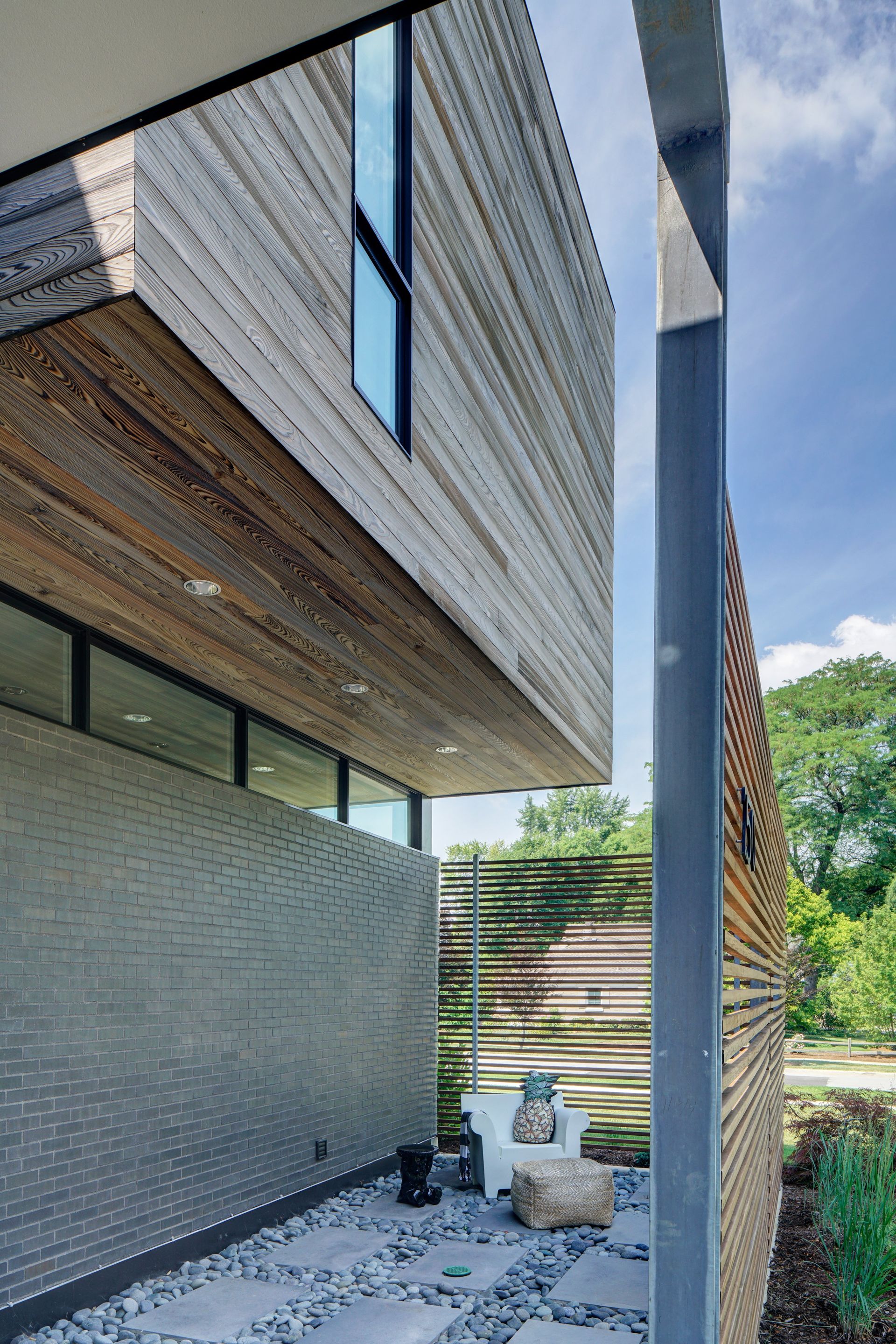 A modern house with a lot of windows and a brick wall.