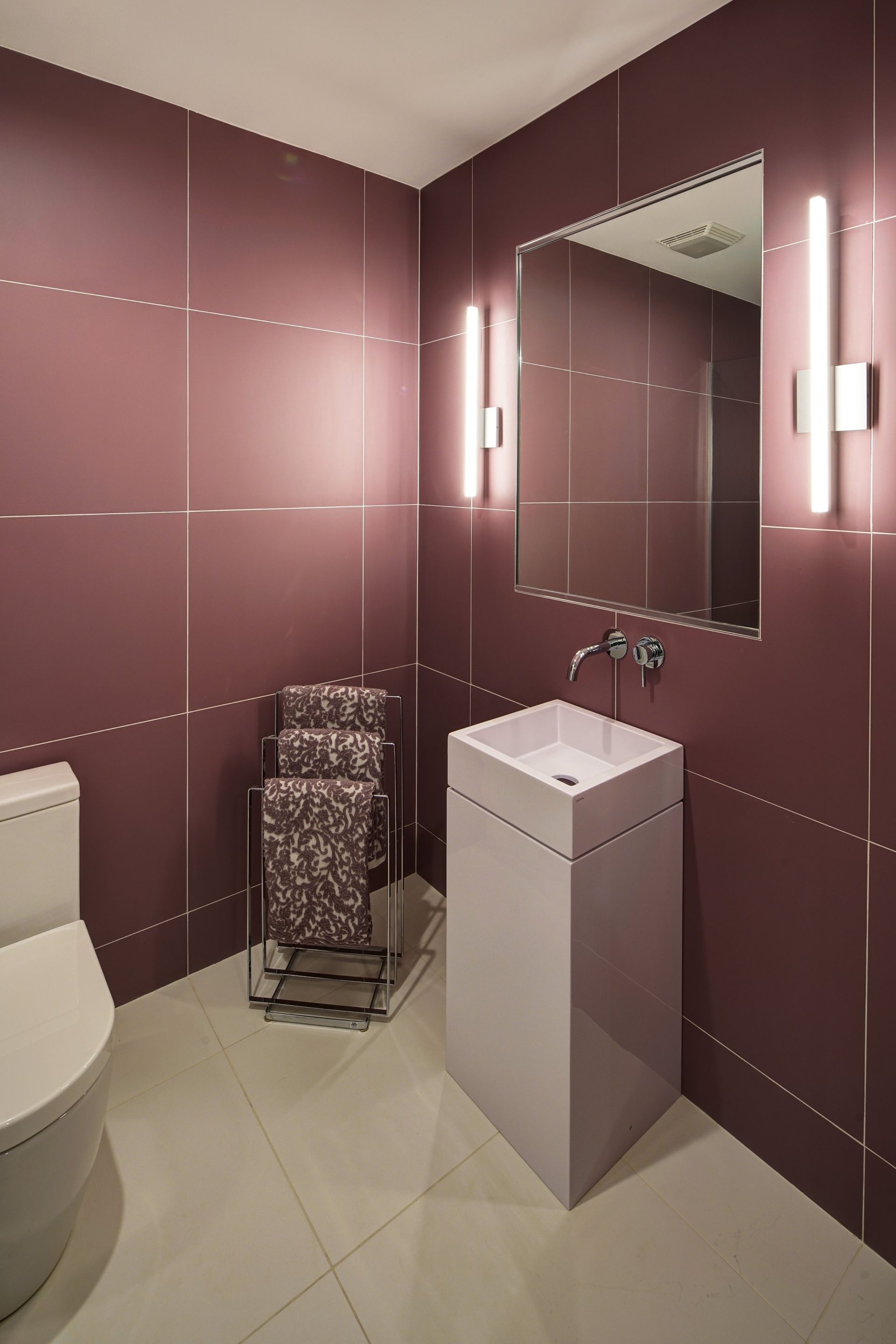 A bathroom with a toilet a sink and a mirror