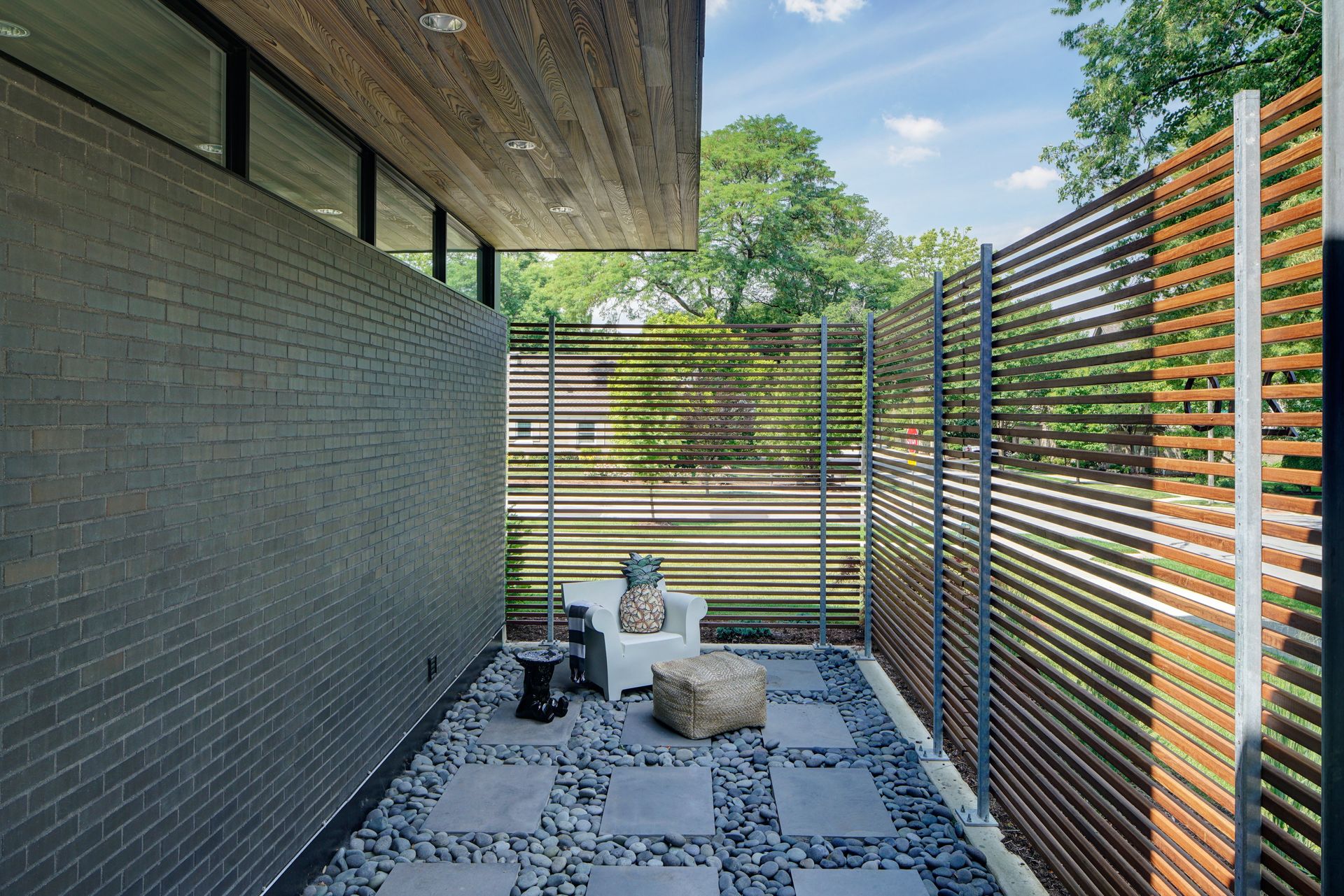 A patio with a wooden fence and a brick wall.