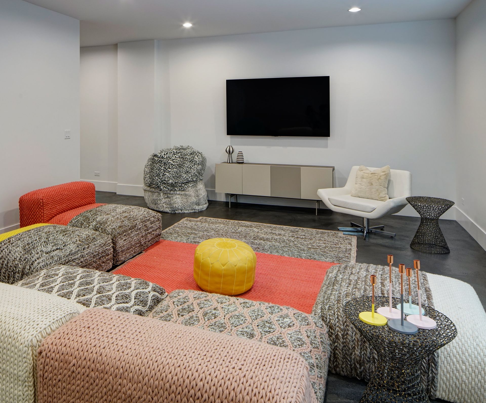A living room with colorful furniture and a flat screen tv