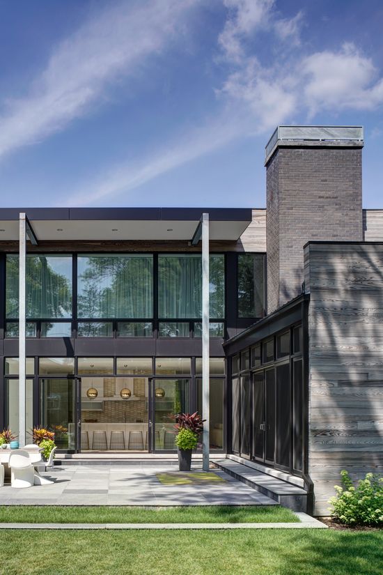 A modern house with a lot of windows and a chimney