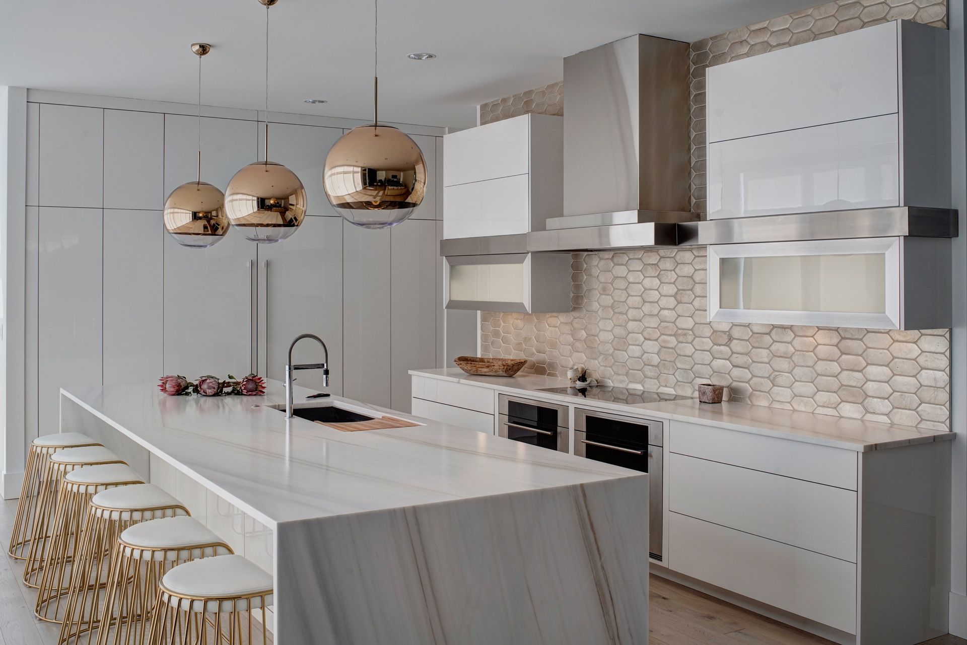 A kitchen with white cabinets , stainless steel appliances , and a large island.