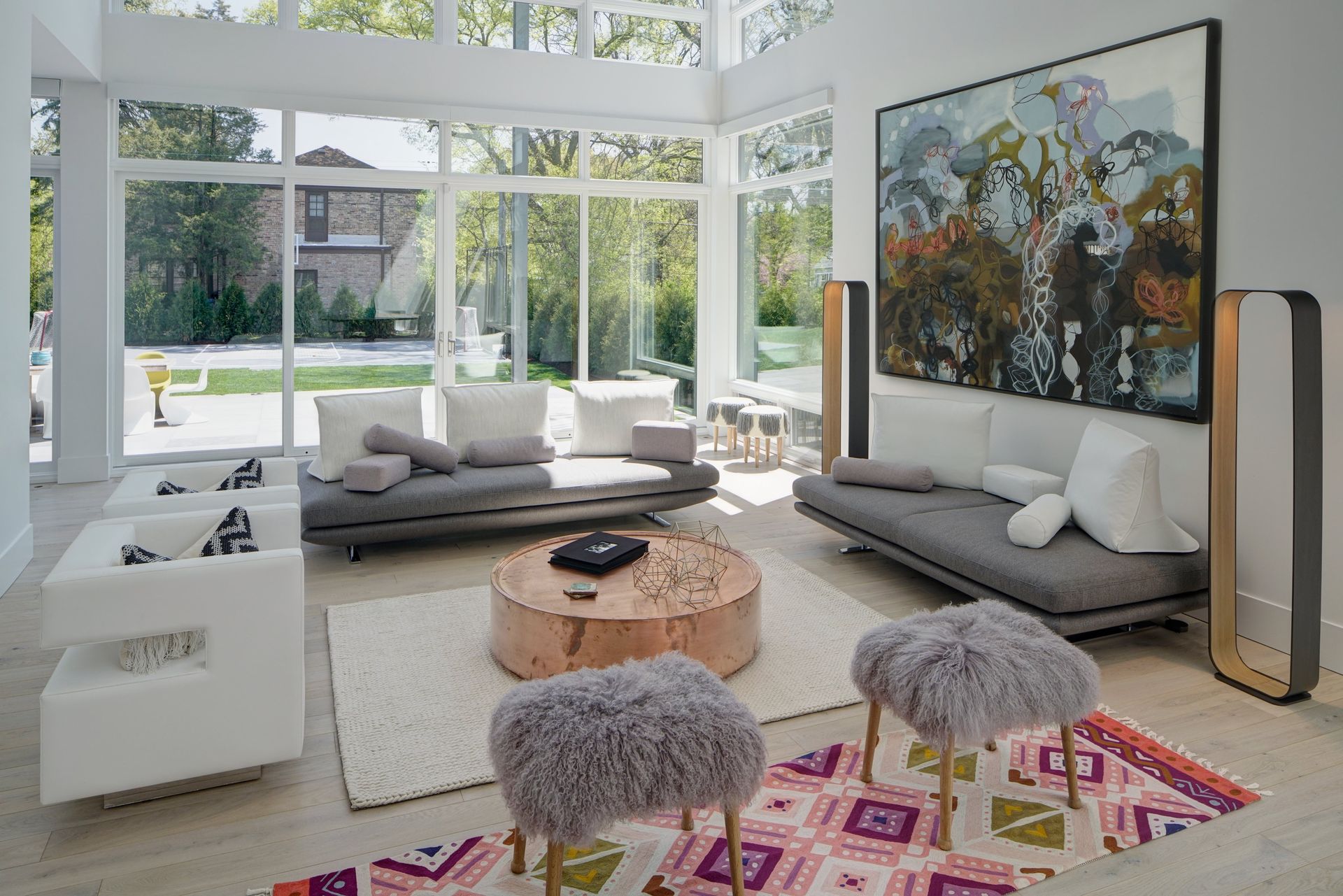 A living room with a couch , chairs , a coffee table and a painting on the wall.