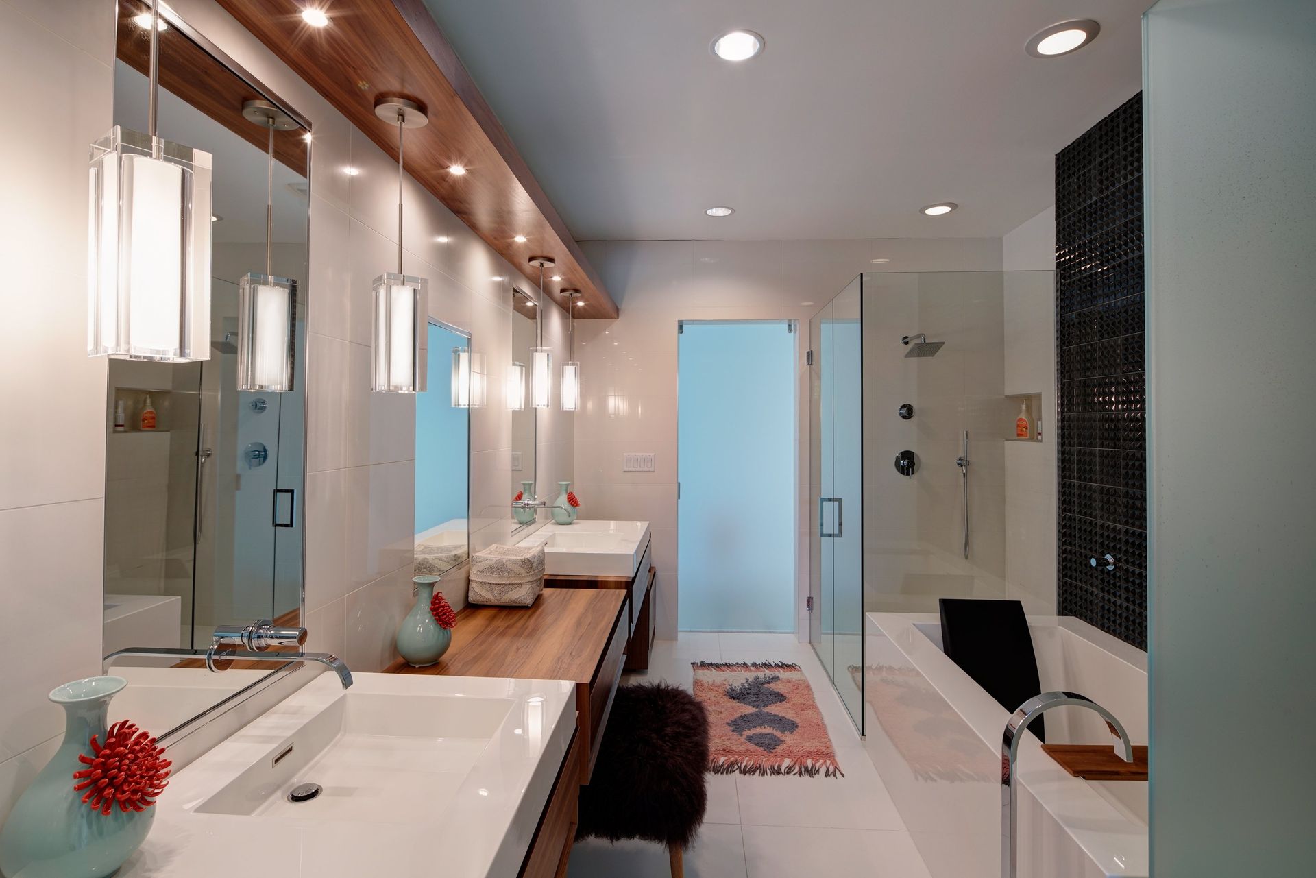 A bathroom with two sinks , a tub and a shower.