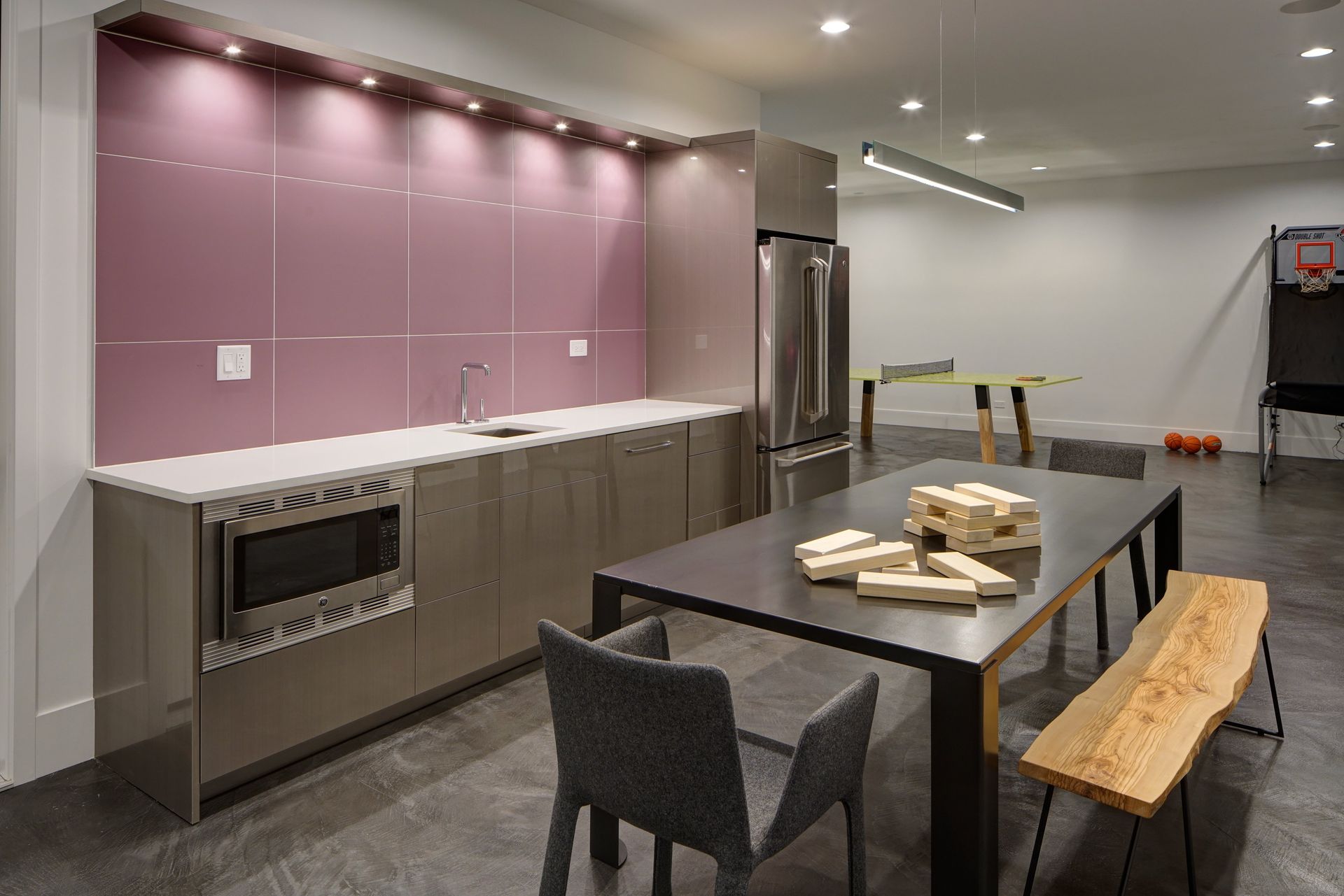 A kitchen with a table and chairs and a basketball hoop.