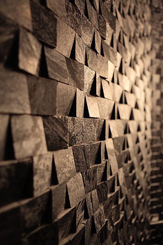 A black and white photo of a wall made of wooden blocks.