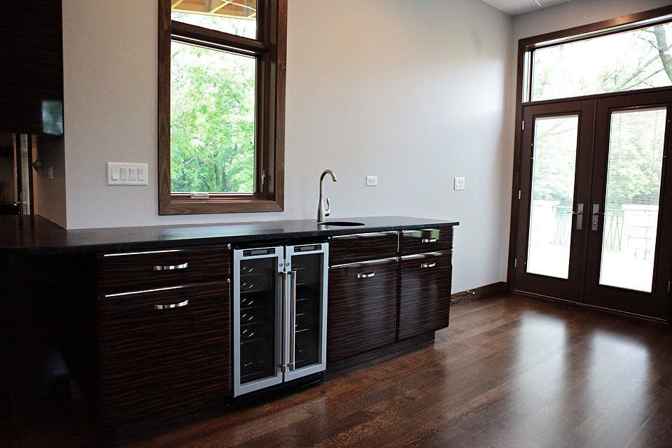 A kitchen with a sink , refrigerator , and a window.