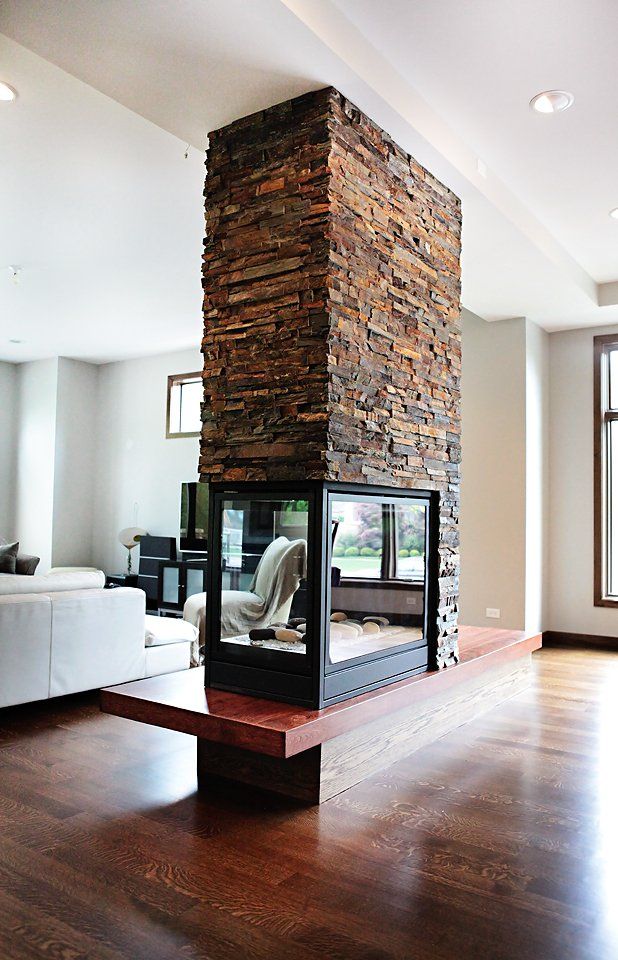A living room with a stone fireplace and a couch.