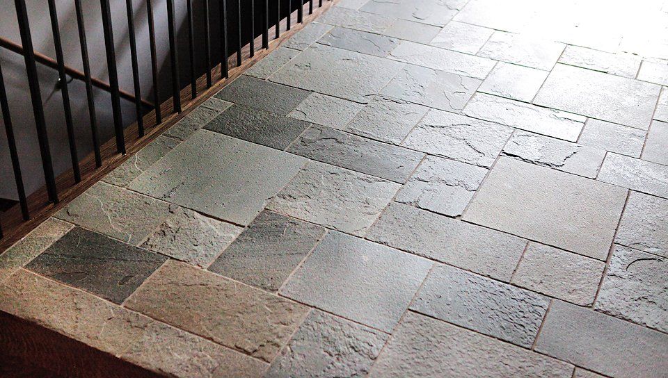 A staircase with a brick floor and a metal railing