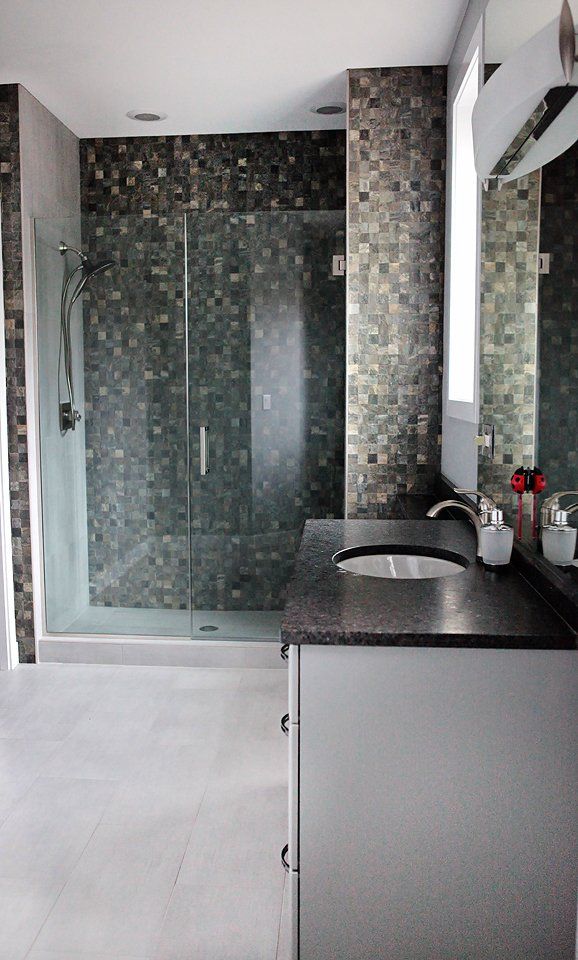 A bathroom with a sink and a walk in shower.