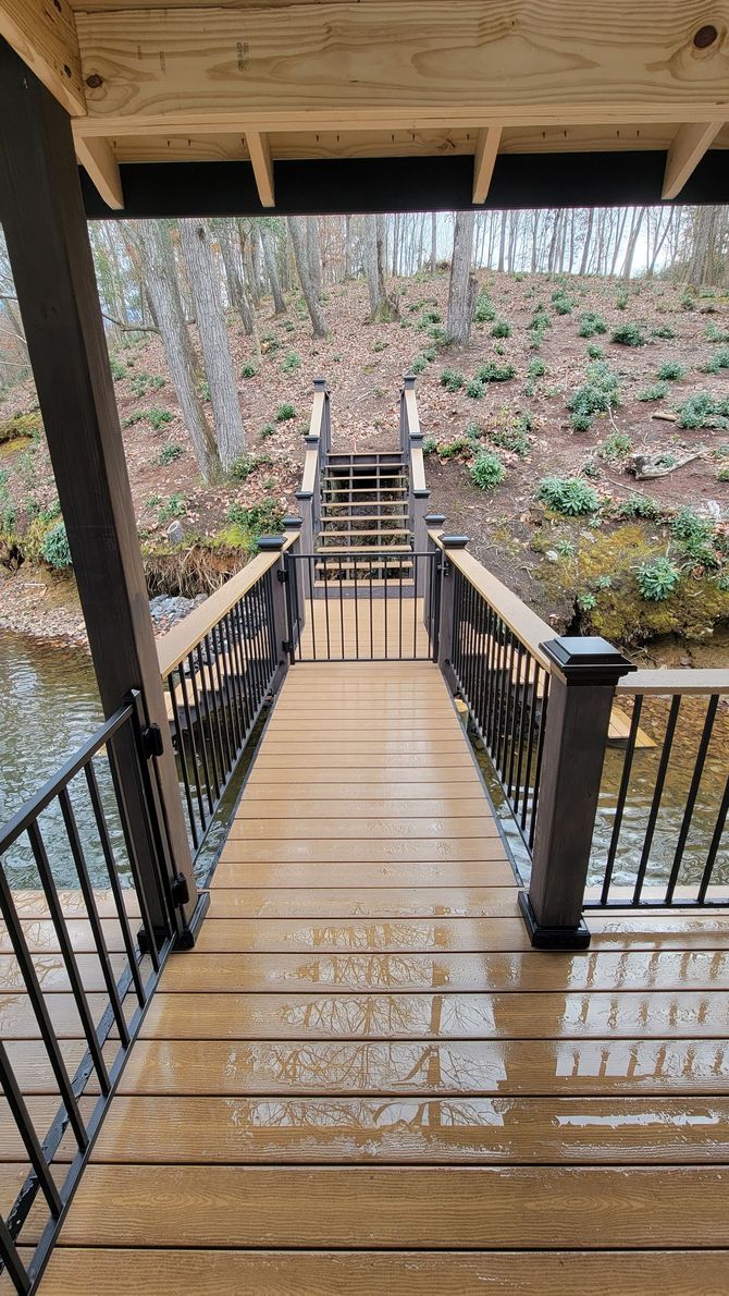 A wooden deck with stairs leading to a river.