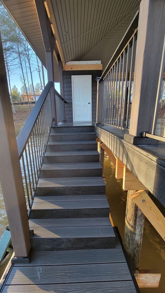 A set of stairs leading up to a door on a bridge over a body of water.