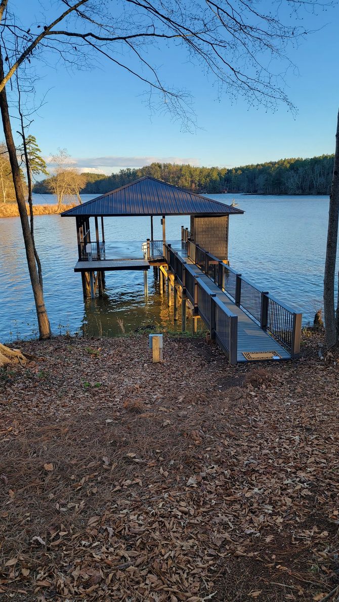 A dock on a lake with a gazebo on top of it.