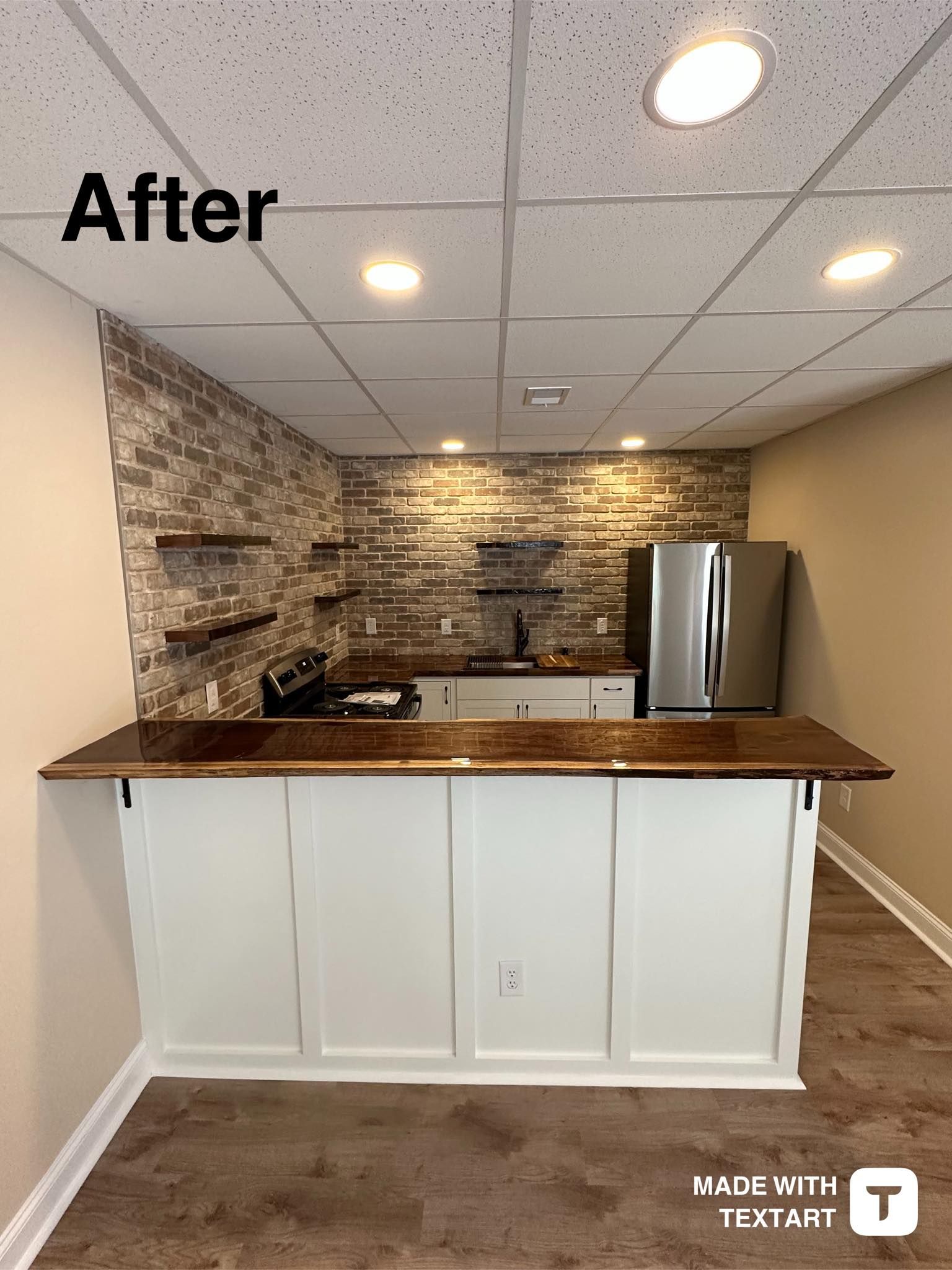 A kitchen with a wooden counter top and a brick wall.