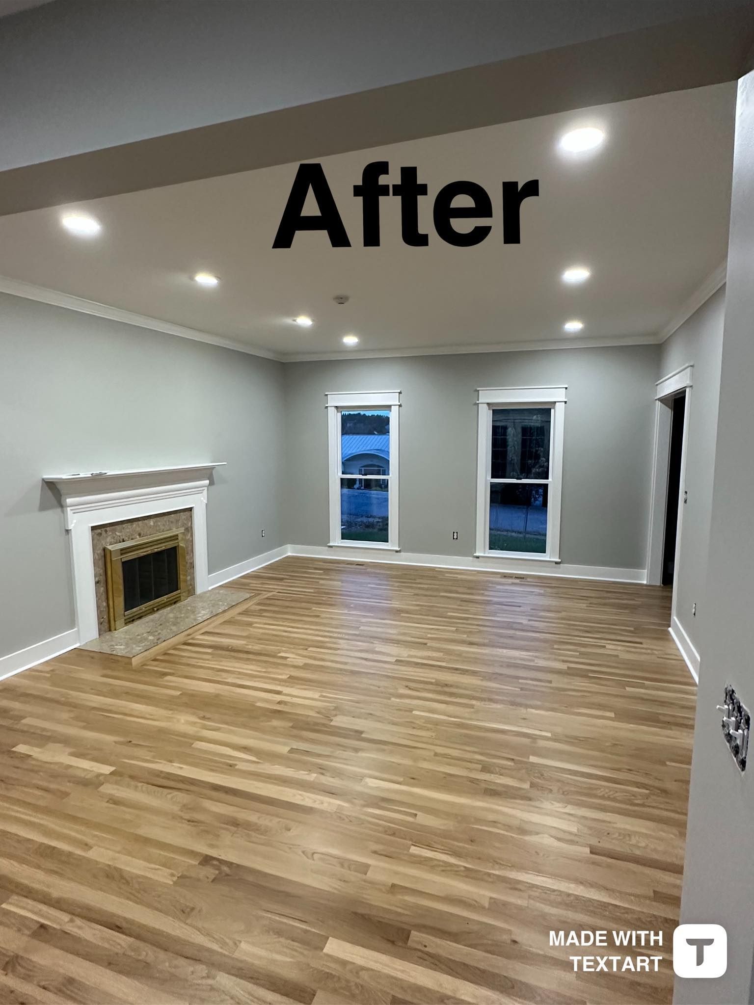 An empty living room with hardwood floors and a fireplace.
