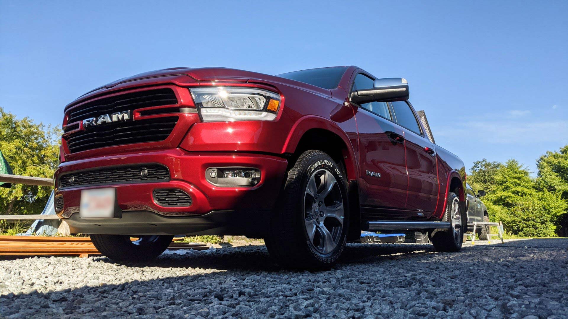 A red ram truck is parked on a gravel road.