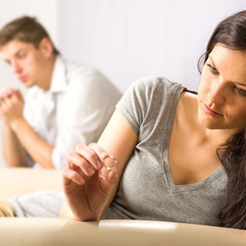 A woman is sitting at a table with a man in the background