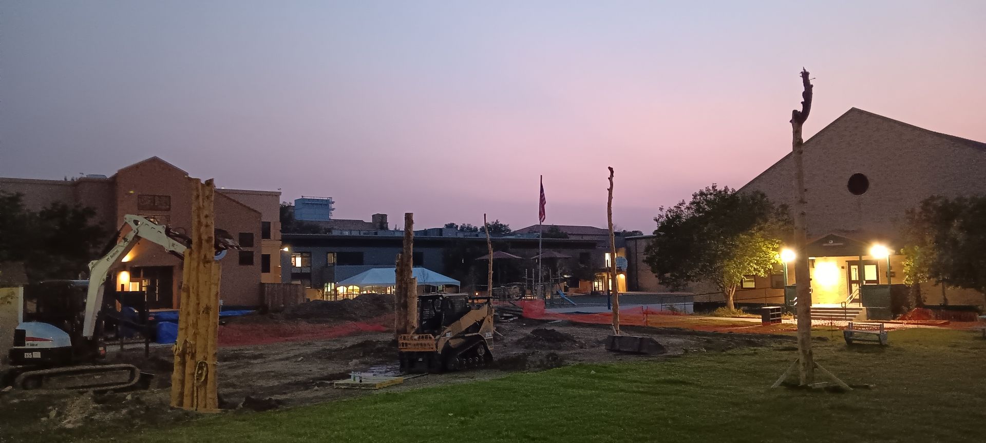 A construction site with a sunset in the background.