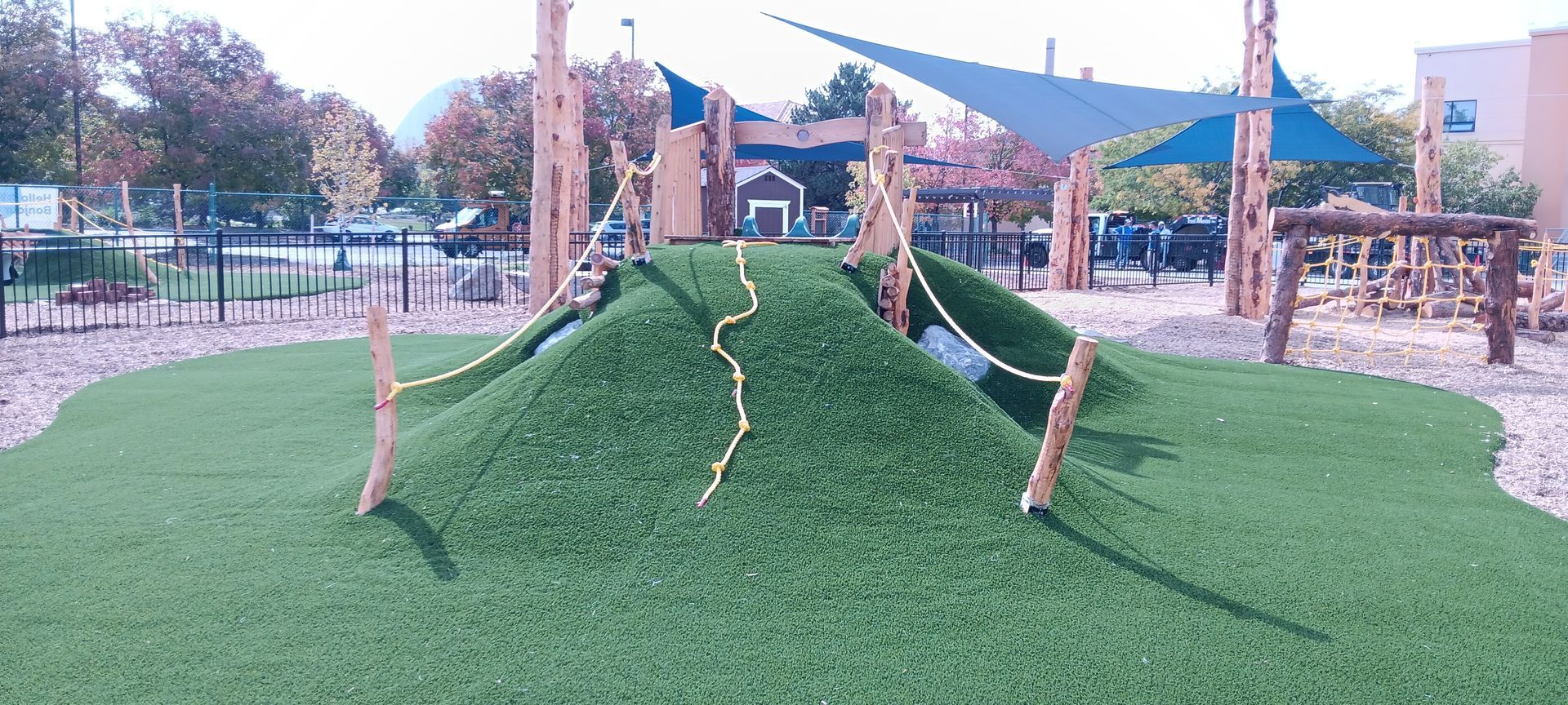 A playground with a grassy hill and a slide.