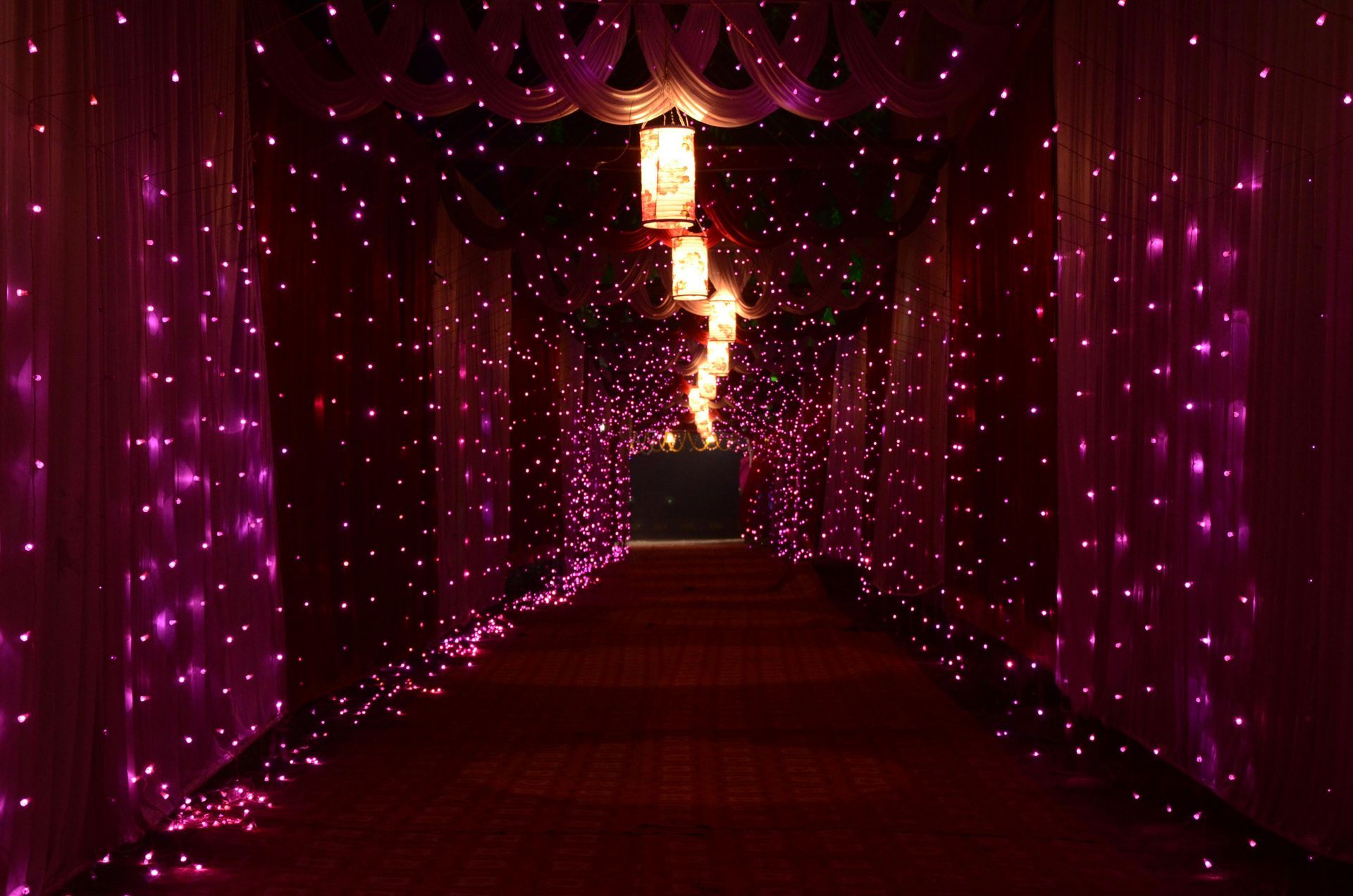 A hallway with purple lights on the walls and a red carpet