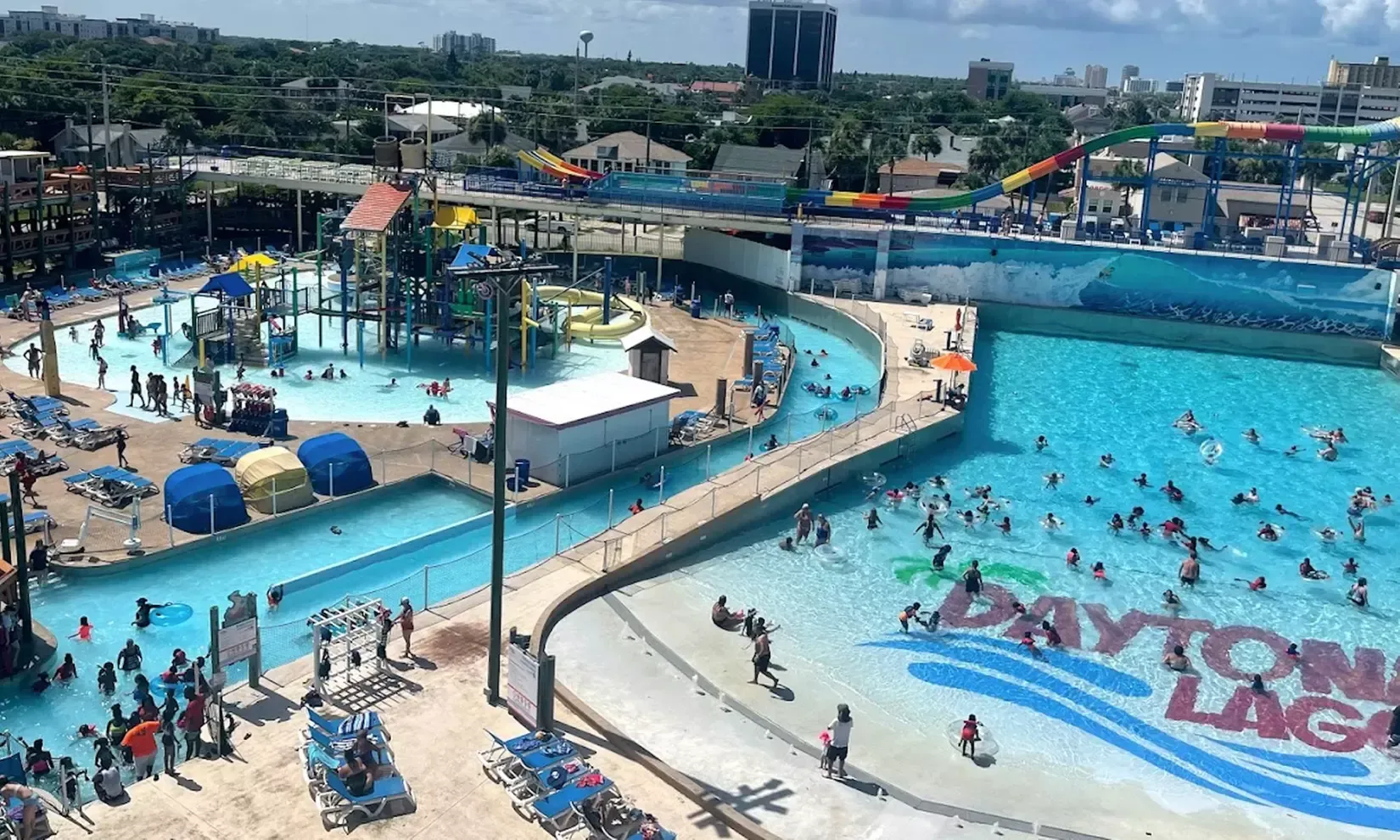 Aerial view of a crowded Daytona Lagoon waterpark with pools, slides, and a wave pool; sunny day.