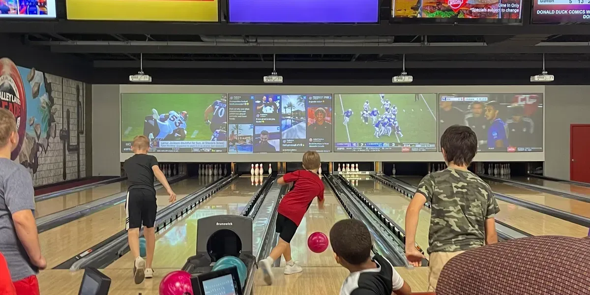 Large, old oak tree with white picket fence around the base, Spanish moss hanging from branches.