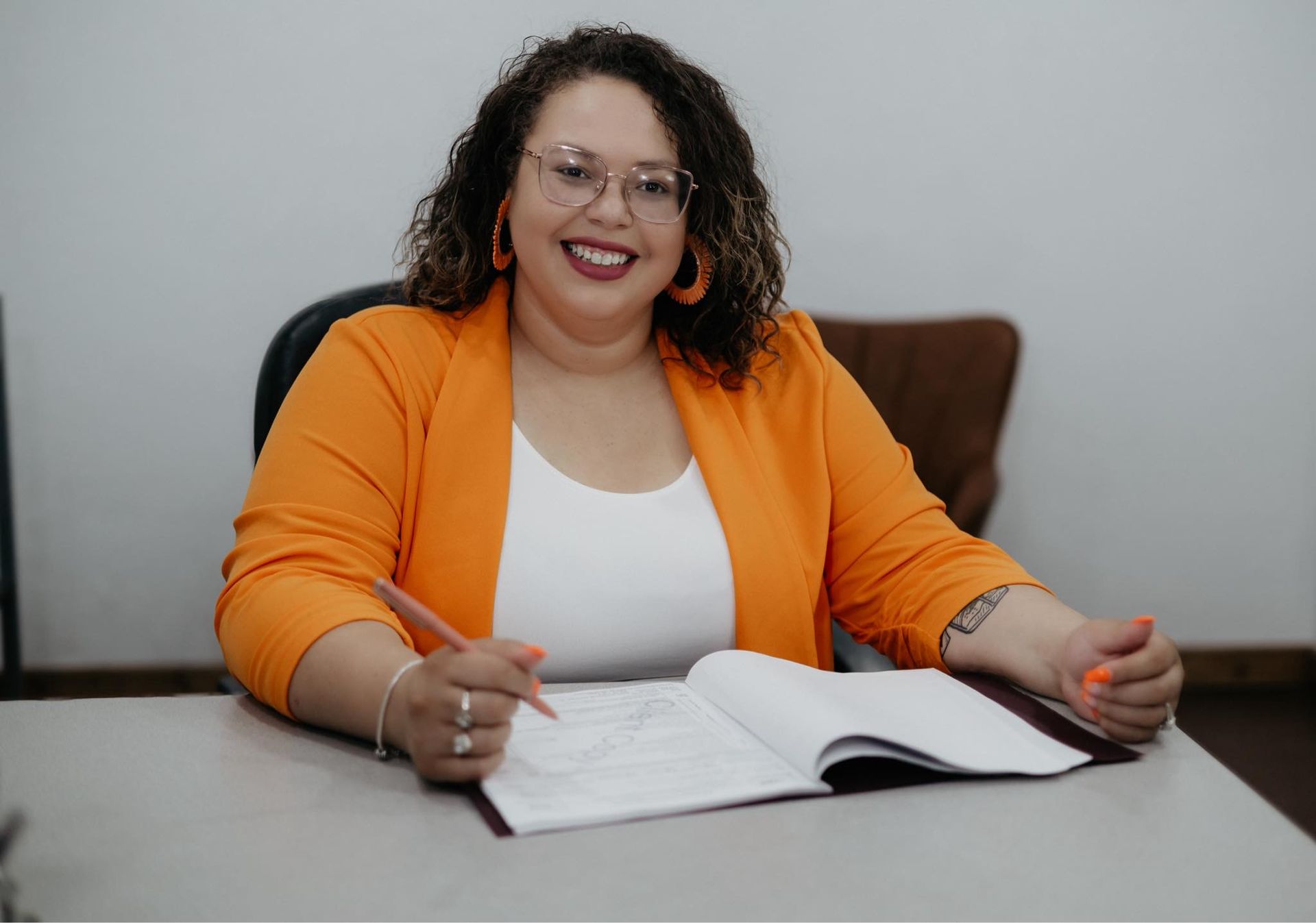 A woman is sitting at a desk writing in a notebook.