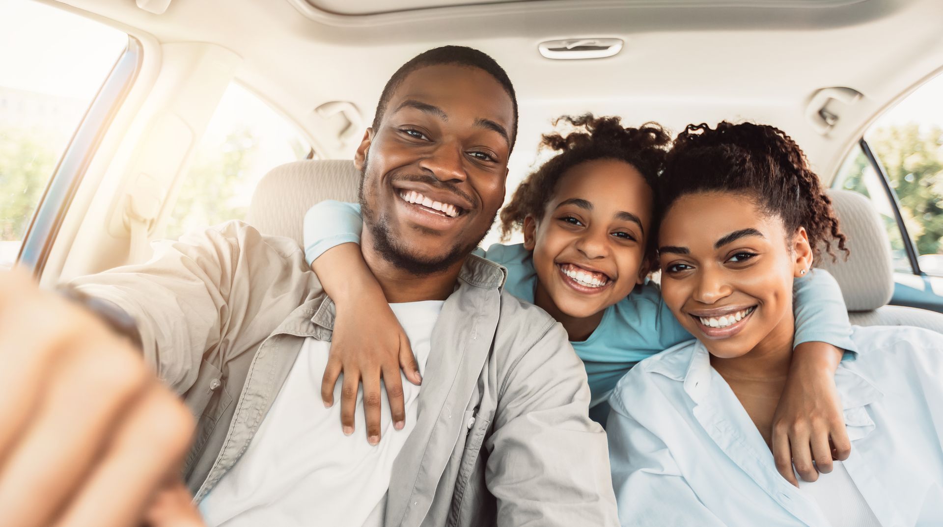 A family is taking a selfie in the car.