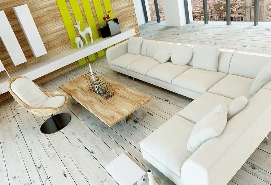 Modern living room with a large white sectional sofa, a wooden coffee table, a wicker chair, and a bright green accent wall.