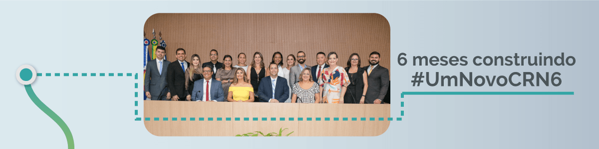 Um grupo de pessoas em pé, uma ao lado da outra, em um palco.