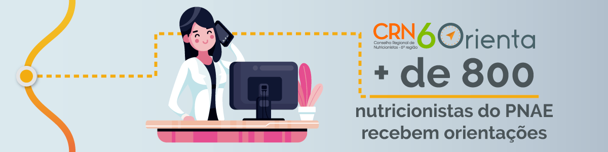 Uma mulher está sentada em uma mesa em frente a um computador.