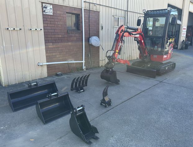 Excavator with bucket attachments and auger bits 