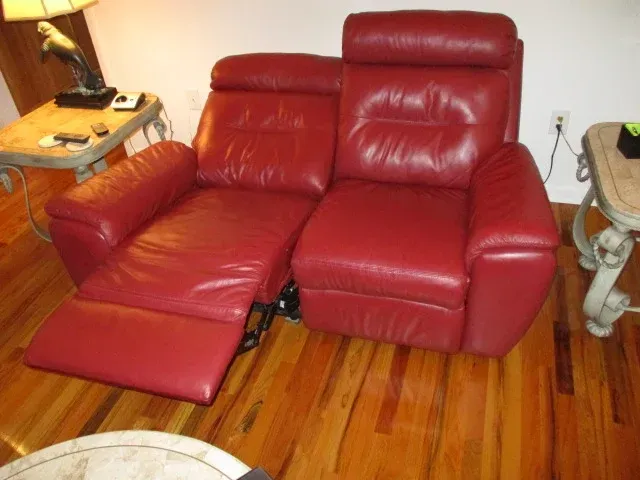 A red leather recliner is sitting in a living room
