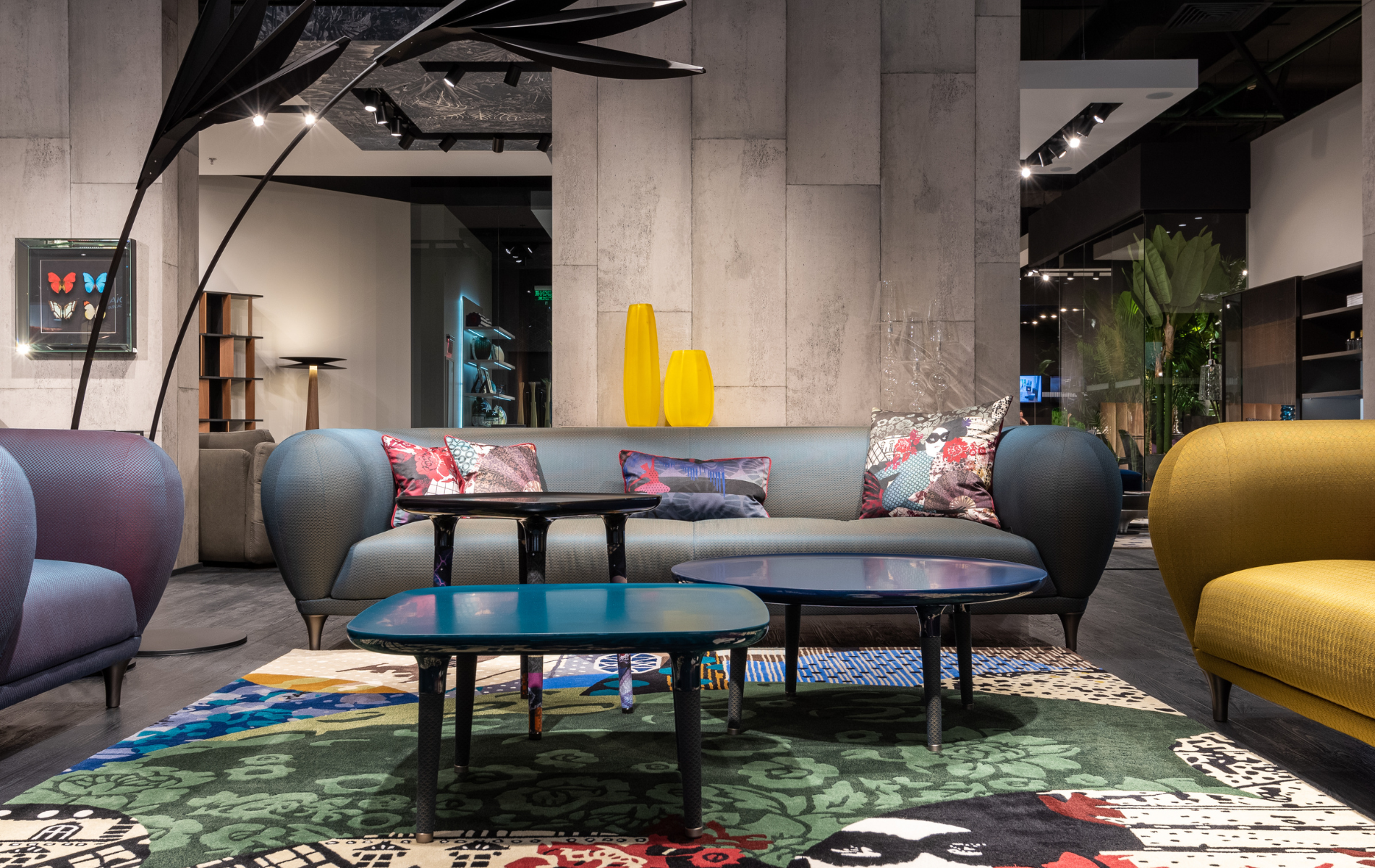 A living room with a couch , chairs , tables and a rug.