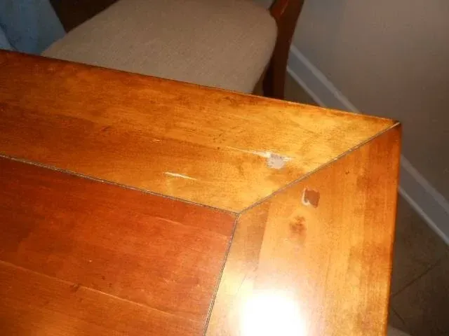 A wooden table with a chair in the background