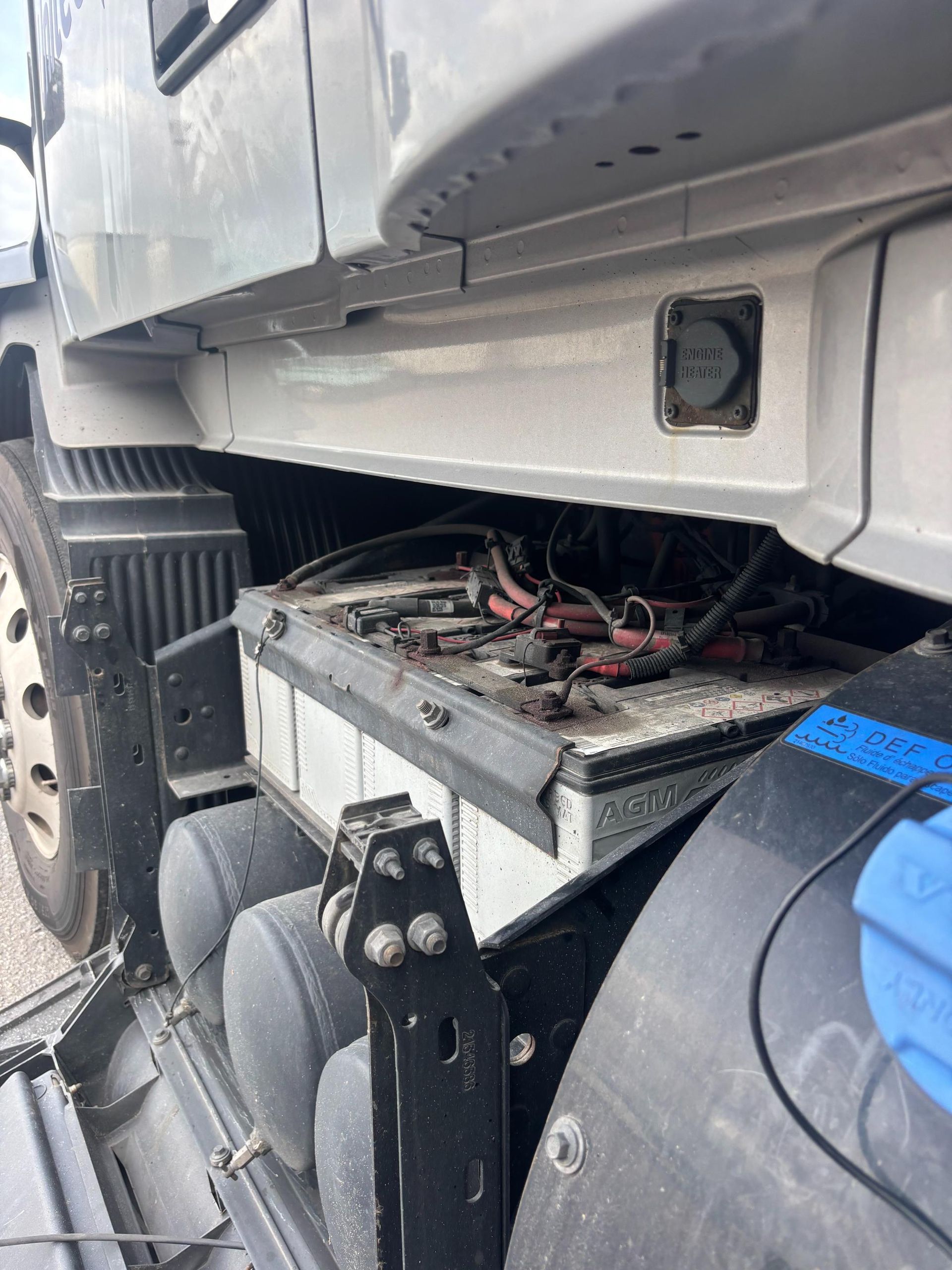 Truck battery compartment with batteries and wiring. Side view.