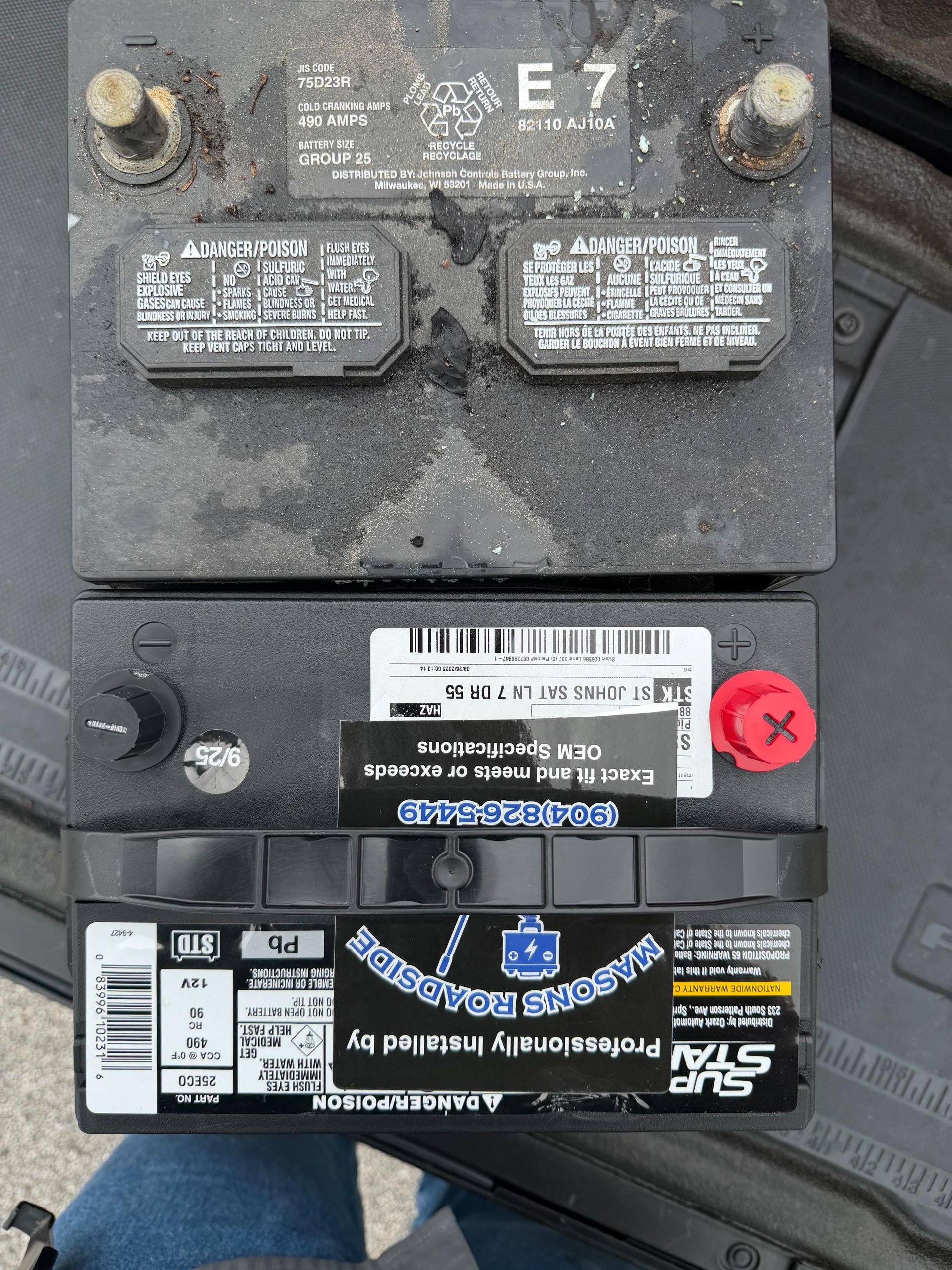 Two car batteries, one old and dusty, the other new, side by side.