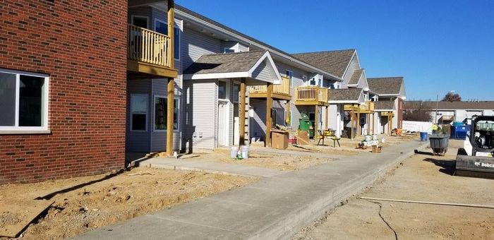 A row of apartment buildings under construction on a sunny day