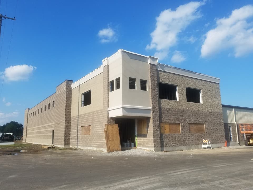 A large brick building under construction with a blue sky in the background