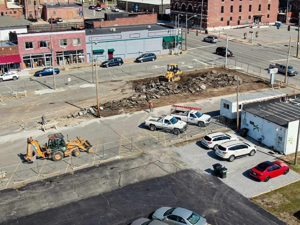 An aerial view of a parking lot with cars parked in front of a building