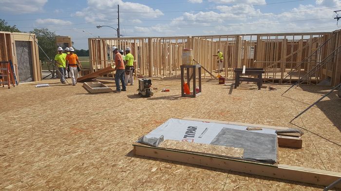 A group of construction workers are working on a house under construction